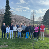Eine Gruppe Golfer bei der Siegerehrung, im Hintergrund Bäume und ein Berg im Sauerland bei blauem Himmel