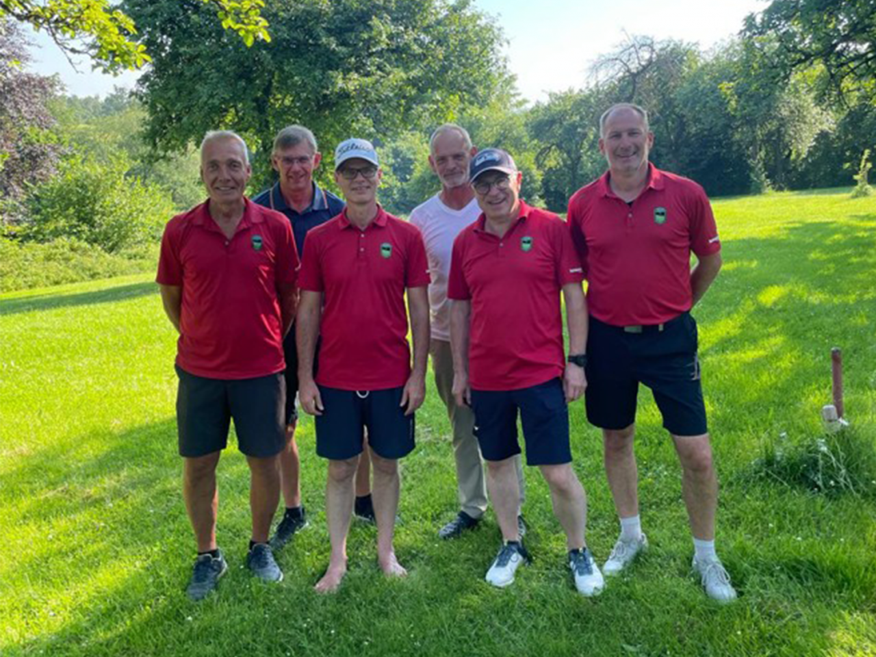 Die sechs Golfer des GC Schmallenberg in roten Shirts und dunklen Hosen in grüner Natur